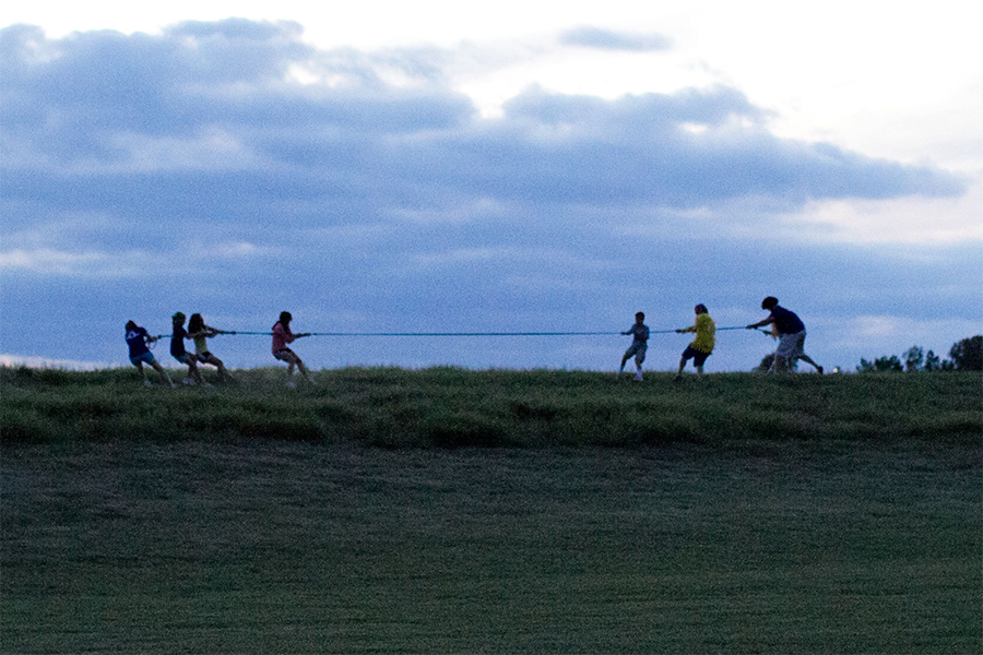 Kids playing tug of war at sunset